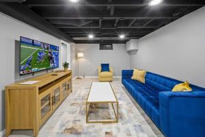 a living room with a blue couch and a tv at Elegant Oasis 4 Bedroom Home Away from Home in Utica