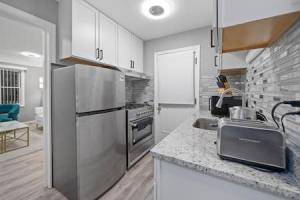 a kitchen with a stainless steel refrigerator and a counter at Urban Elegance Retreat in Downtown Rochester in Rochester