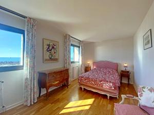 a bedroom with a bed and a table and a window at RÉF 318 - LARMOR-PLAGE spacieux type 3 pleine vue mer avec terrasse, ascenseur, parking in Larmor-Plage