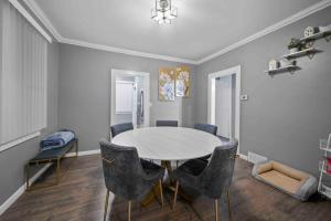a dining room with a white table and chairs at Cozy 3bd home in downRoyal Oak in Royal Oak