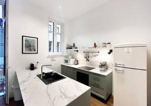 a kitchen with white marble counter tops and a refrigerator at Palermo Blu - Palazzo Pirrotta in Palermo