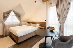 1 dormitorio con 1 cama, mesa y sillas en Kavenija apartmaji - Free Parking, en Maribor