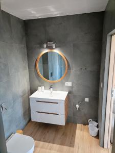 een badkamer met een wastafel en een spiegel bij Apartamenty Kaniówka 25 in Gliczarów Górny