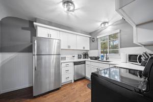 a kitchen with white cabinets and a stainless steel refrigerator at Charming Urban Retreat in Downtown Birmingham in Birmingham