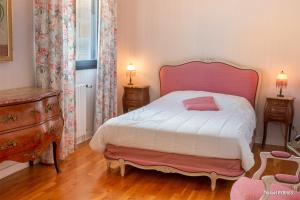 a bedroom with a large bed with a pink headboard at RÉF 318 - LARMOR-PLAGE spacieux type 3 pleine vue mer avec terrasse, ascenseur, parking in Larmor-Plage +20 photos