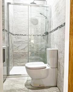 Un inodoro blanco en un baño con ducha. en Town Centre Apartment Harrogate, en Harrogate 5 fotos más