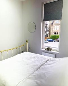Un dormitorio con una cama blanca y una ventana. en Town Centre Apartment Harrogate, en Harrogate
