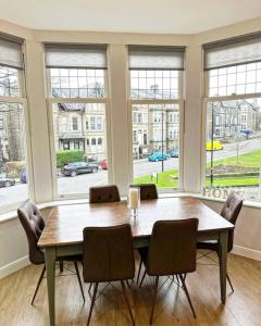 comedor con mesa, sillas y ventanas en Town Centre Apartment Harrogate en Harrogate