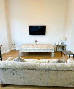 una sala de estar con un sofá y una mesa en Town Centre Apartment Harrogate, en Harrogate