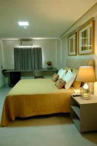 a hotel room with a large bed with a lamp at Hotel Neblina in Araguaína