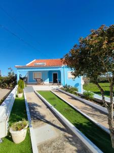 ein blaues Haus mit Garten und Baum in der Unterkunft Vivenda Palheiras in Roncão