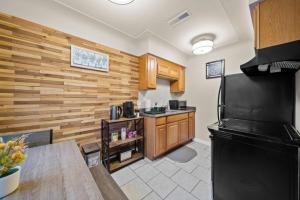 Modern Cozy 1 Bedroom Apartment in Shelby Township في Shelby: مطبخ بجدران خشبية وثلاجة سوداء