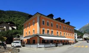 a large orange building on the side of a street at Boutique und Bier Hotel des alpes in Fiesch