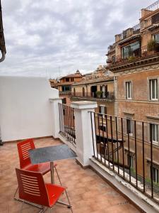 einen Balkon mit 2 Stühlen und einem Tisch auf einem Gebäude in der Unterkunft Hotel Erdarelli in Rom