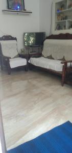 sala de estar con 2 camas y alfombra azul en Jestine Homestay en Kochi