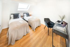 - une chambre avec 2 lits et un bureau avec un ordinateur portable dans l'établissement Luxury 4 Beds 2 Bath Near City Centre Freeparking, à Southampton