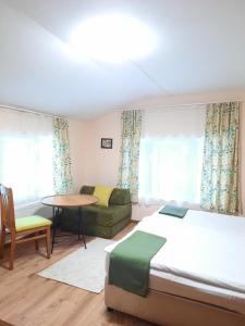 a bedroom with a bed and a couch and a table at Villa Sveti Dimitar in Borovets