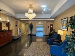 eine Lobby eines Krankenhauses mit einer blauen Couch und Stühlen in der Unterkunft Tapa Hotel, Inn & Suites in Mahwah