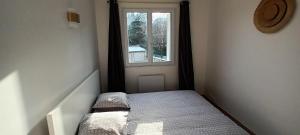 Habitación pequeña con cama y ventana en Appart à Versailles, 2 à 4 pers, avec parking, en Versalles