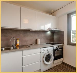 een witte keuken met een wastafel en een wasmachine bij Studio Paisible Annemasse in Annemasse