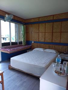 a bedroom with a large bed and two windows at Shiva's Hippies Colony in Sauraha