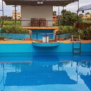 a swimming pool with a small house on top of it at Shiva's Hippies Colony in Sauraha