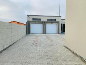 two garage doors on a building with a brick driveway at TALITHA'S SELF-CATERING ACCOMONDATION in Walvis Bay