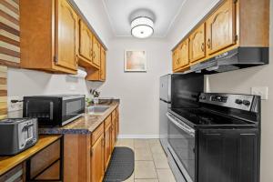 cocina con fogones negros y microondas en Modern Cozy 1 Bedroom Apartment in Shelby Township, en Shelby