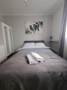 a bedroom with a large bed with two pillows on it at Apartament pod szczęśliwą 13 in Toruń