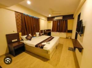 a hotel room with a bed and a television at HOTEL GINGER GOLD in Pune