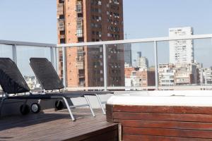 Duas cadeiras numa varanda com vista para a cidade em Abedul Deluxe Apartment em Buenos Aires