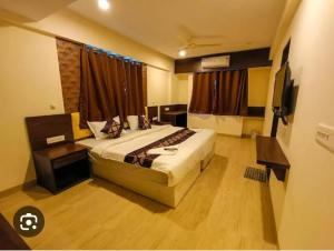 Habitación de hotel con cama y TV en HOTEL GINGER GOLD, en Pune