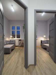 una camera con due letti e un soggiorno di Hola Apartamenty Nawrot a Łódź