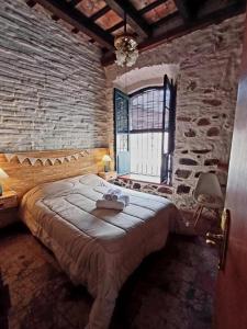 a bedroom with a large bed in a stone wall at Posada San Gabriel in Colonia del Sacramento