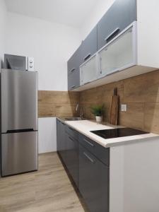 a kitchen with a stainless steel refrigerator and cabinets at Hola Apartamenty Nawrot in Łódź