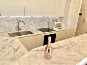 a bottle of champagne sitting on a counter in a kitchen at Botanic Garden Apartment Calandre Beach Ventimiglia in Ventimiglia +41 photos