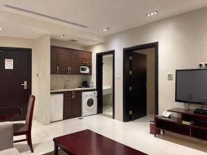 a living room with a tv and a kitchen at Massayef Al Khobar 2 in Al Khobar