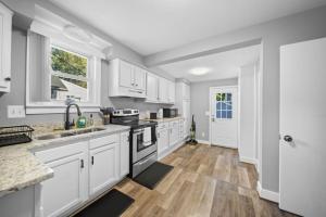 a kitchen with white cabinets and a sink at Stylish Luxury 3bd home in Down Town Royal Oak in Royal Oak