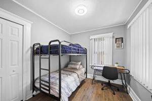 um quarto com um beliche e uma secretária em Stylish Luxury 3bd home in Down Town Royal Oak em Royal Oak