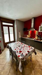 a kitchen with a table with a table cloth on it at L'école du Hameau 9pers Le Mont Dore in Le Mont-Dore +26 photos