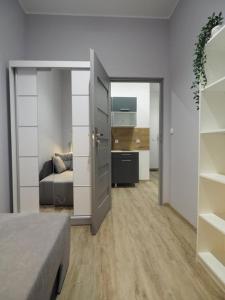 a room with a bedroom with a bed and a kitchen at Hola Apartamenty Nawrot in Łódź