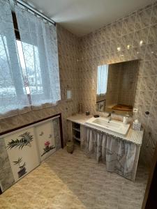 a bathroom with a sink and a large mirror at L'école du Hameau 9pers Le Mont Dore in Le Mont-Dore