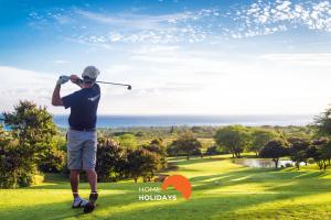 Um homem está a jogar golfe num campo de golfe. em #193 Balcony Ocean View with Pool and AC em Porches