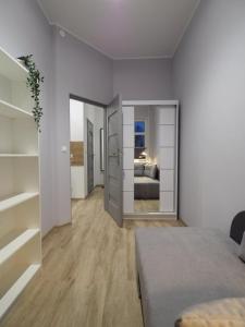 a white room with a bed and a room with a bed sqor at Hola Apartamenty Nawrot in Łódź