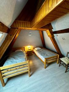 two beds in a room with a attic at L'école du Hameau 9pers Le Mont Dore in Le Mont-Dore