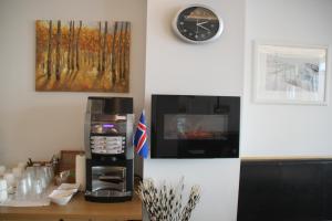 a kitchen with a stove and a clock on the wall at 100 Iceland Hotel in Reykjavík