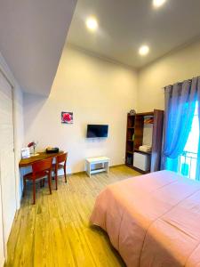 1 dormitorio con 1 cama, escritorio y TV en Casa AGNESE B&B, en Nápoles