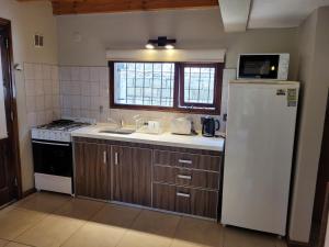 Una cocina con un refrigerador blanco y un fregadero. en morenaaparts, en San Carlos de Bariloche
