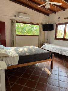 1 dormitorio con 2 camas y ventilador de techo en Cabañas Los Cedros in 
