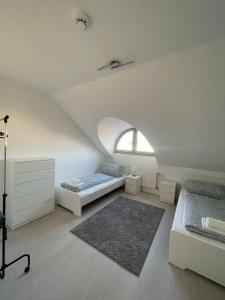 a attic bedroom with two beds and a window at Premium Apartment 3 in Dillingen an der Saar